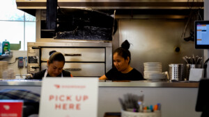 Pick up sign with restaurant workers in background