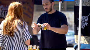 Man in black shirt making ice cream cone for customer