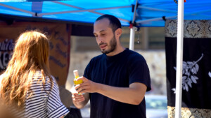 Man in black shirt making ice cream cone for customer