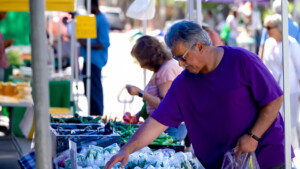 Man in purple shirt shopping at outdoor market