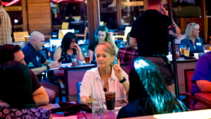 Woman in white shirt having conversation with friends at table