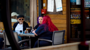 Three people sitting at an outdoor table at a resturant